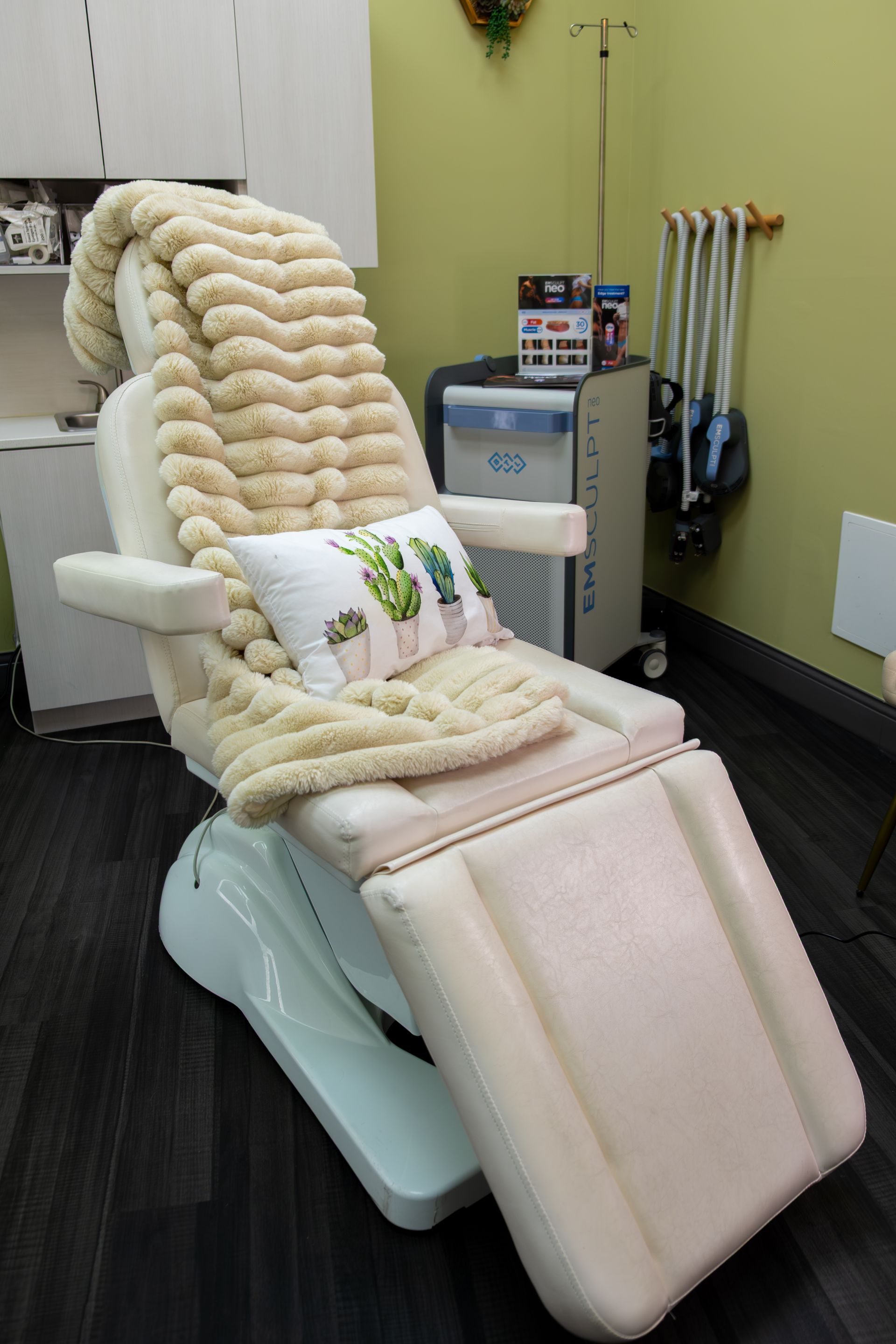 Massage chair in a clinic room with a thick cream blanket and a white pillow.