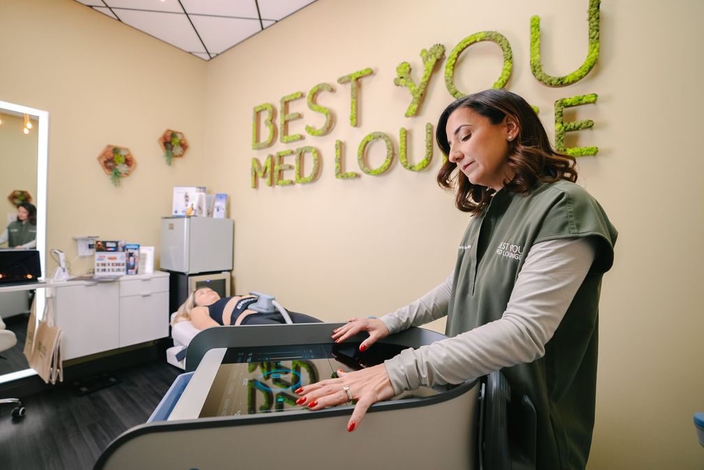 Reception area with a woman at a desk beneath a “Best You Med Lounge” sign