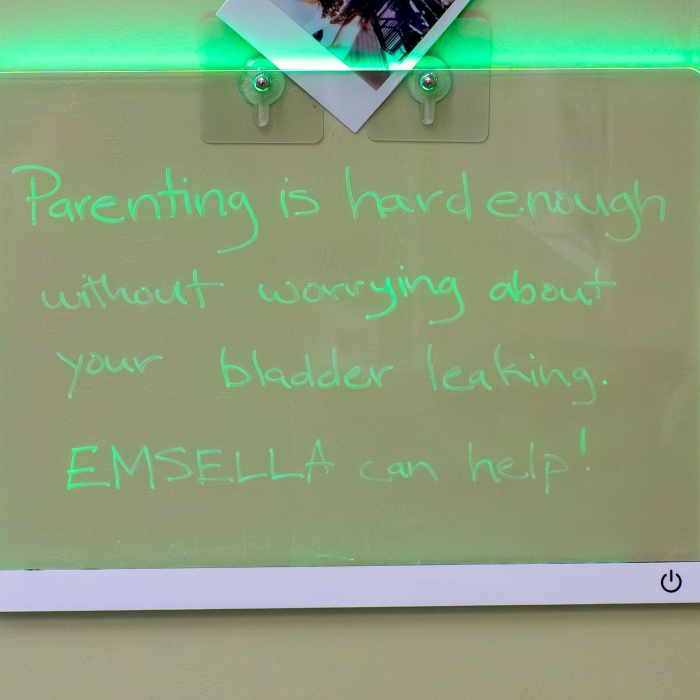 Glowing green neon whiteboard with handwritten quote and a small photo clipped at the top.