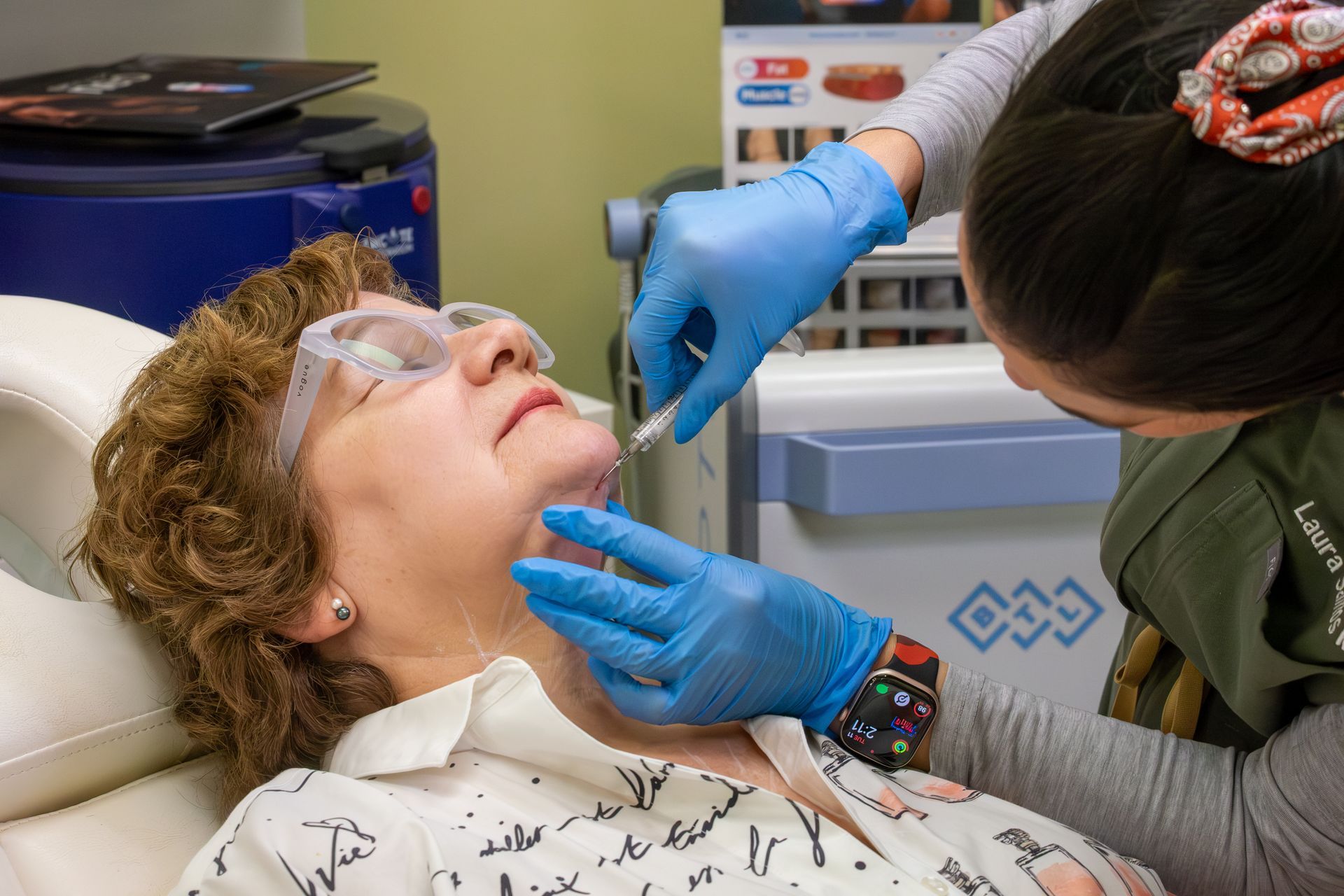 Dental hygienist cleaning a patient’s teeth in a clinic, with gloves and protective glasses.