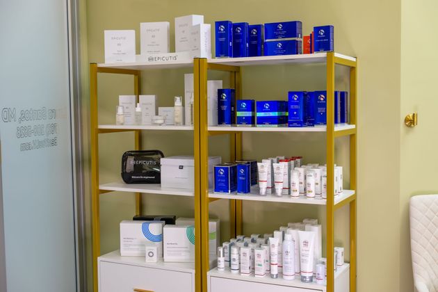 Shelves of blue and white boxed products in a store or stockroom beside a whiteboard