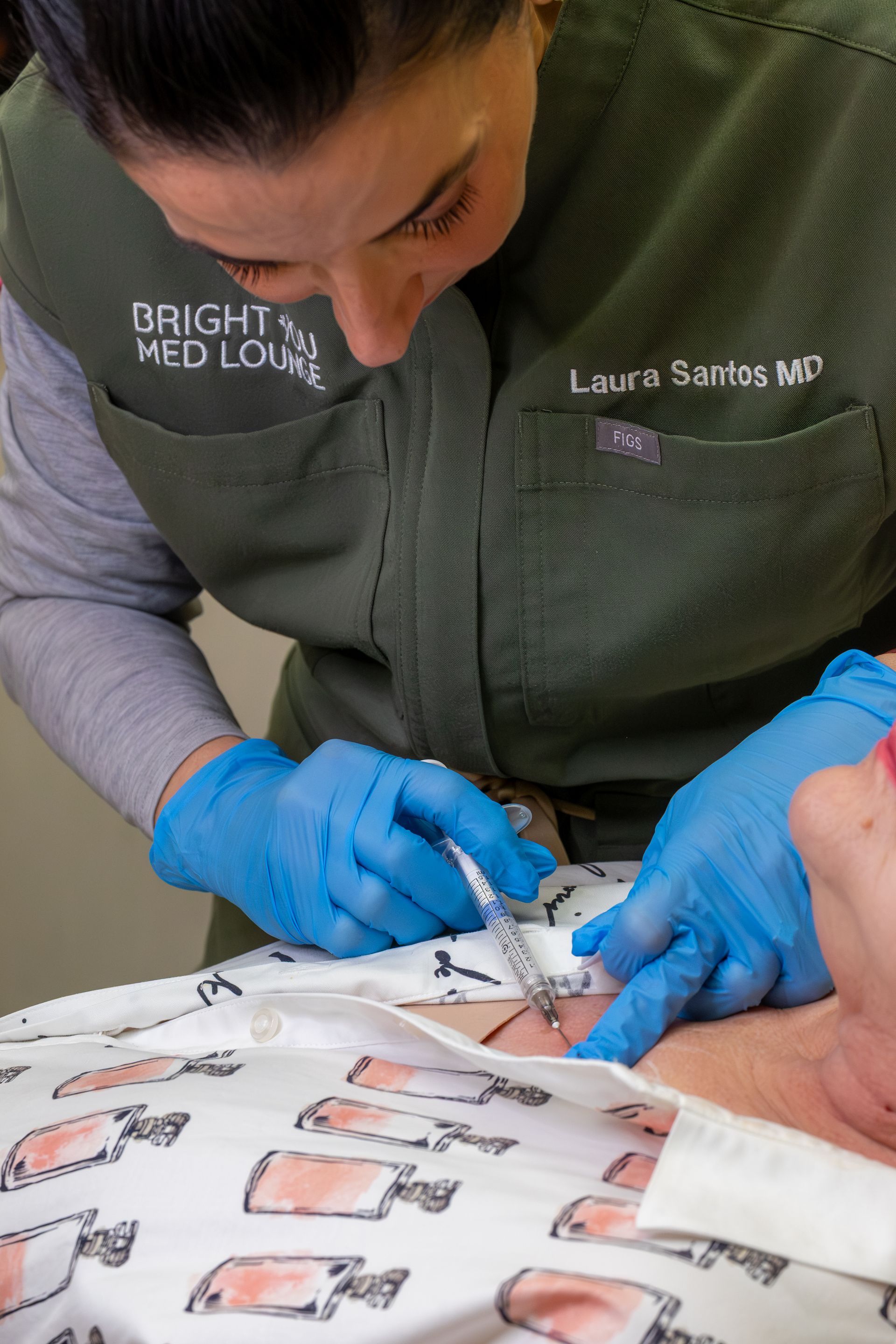 Medical professional in blue gloves adjusting electrodes on a patient during a procedure