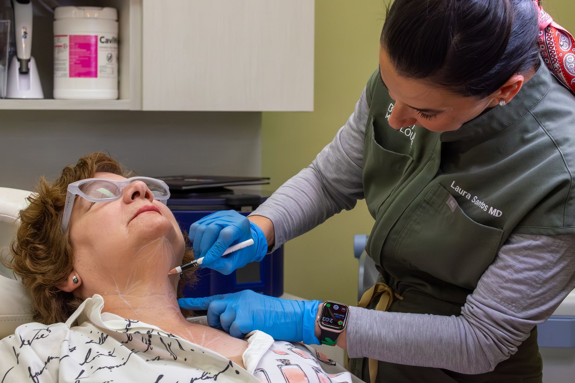 Medical worker in blue gloves examining a patient’s throat in a clinic