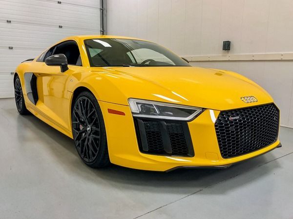 Yellow Audi R8 sports car, black wheels, inside a garage.
