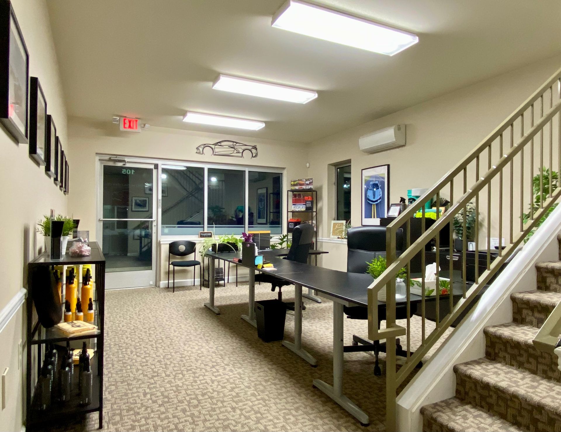 Bright office lobby with desks, chairs, stairs, and fluorescent lights.