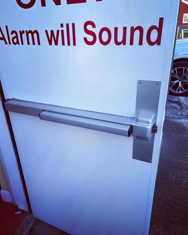 A white door with the words alarm will sound on it