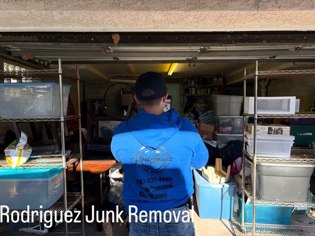 Person in blue jacket standing in a cluttered garage, with a