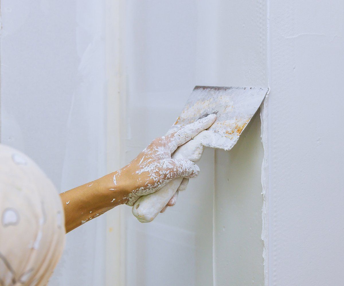 Person Doing Drywall Repair — Longmont, CO — Francia's Painting LLC Person Doing Drywall Repair — Longmont, CO — Francia's Painting LLC
