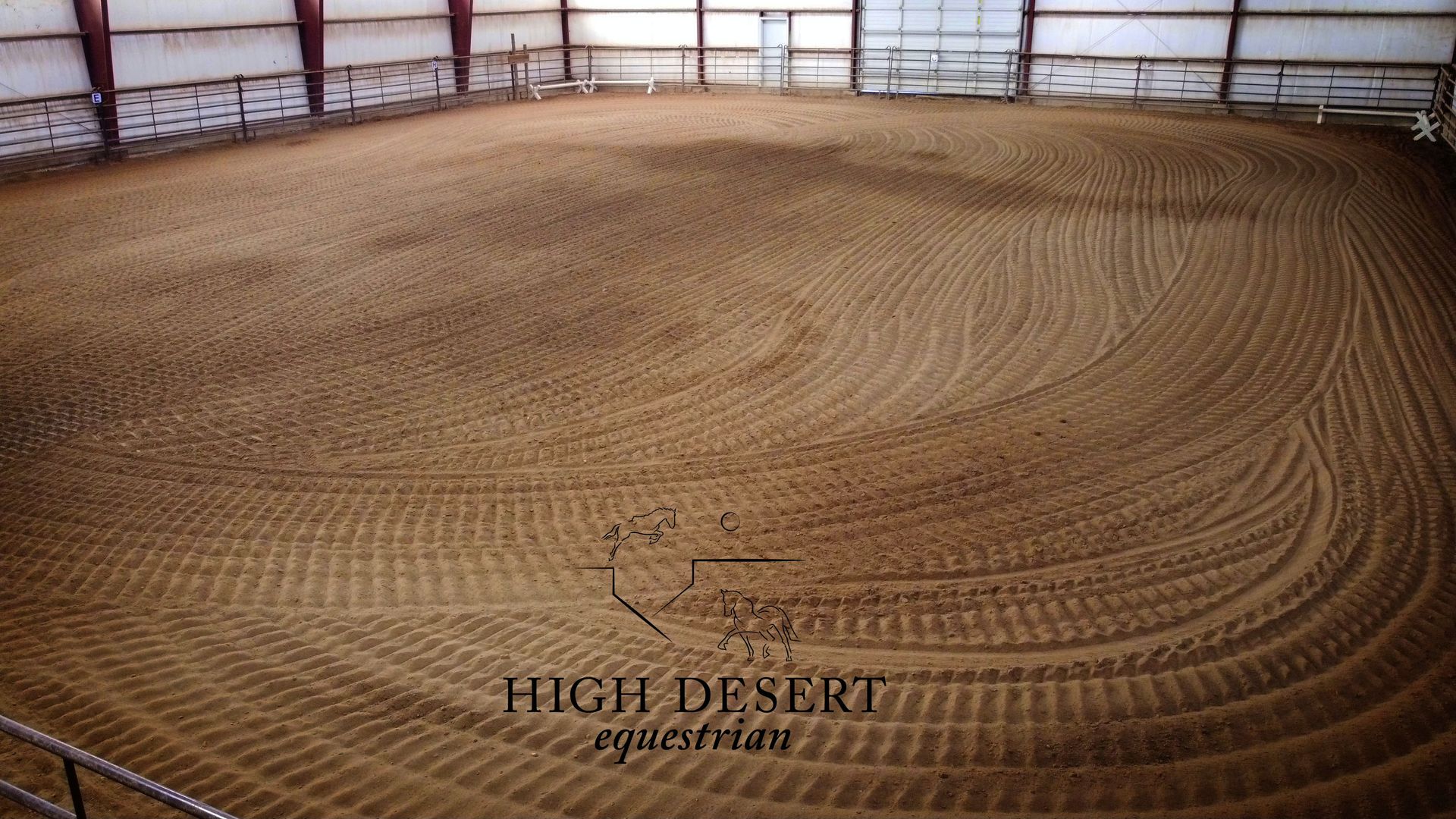 A large dirt arena with the words high desert equine farm on the bottom