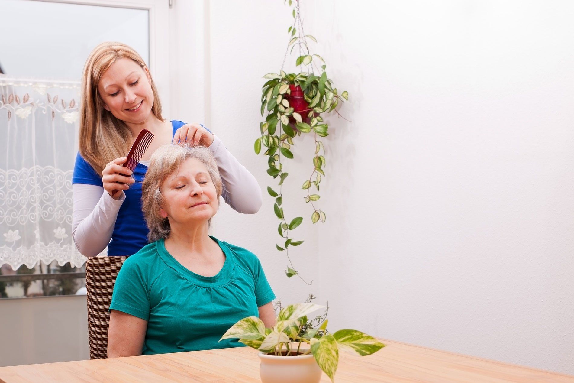 in-home caregiver doing an elderly woman's hair