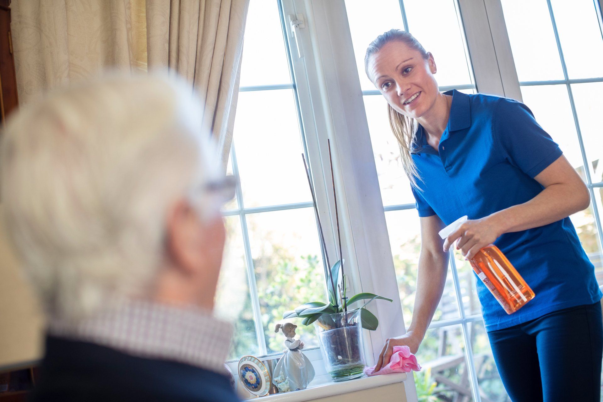 in-home caregiver cleaning house for elderly client