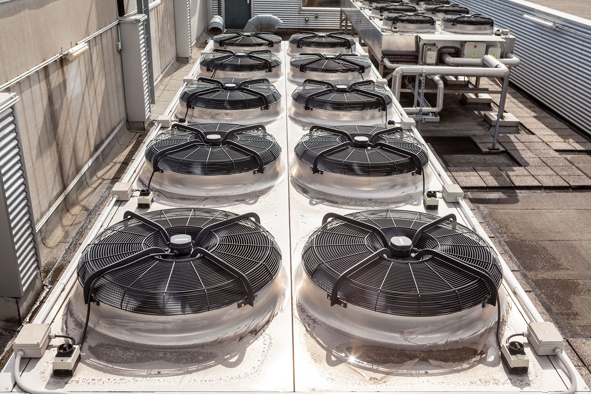 There are a lot of fans on the roof of a building.