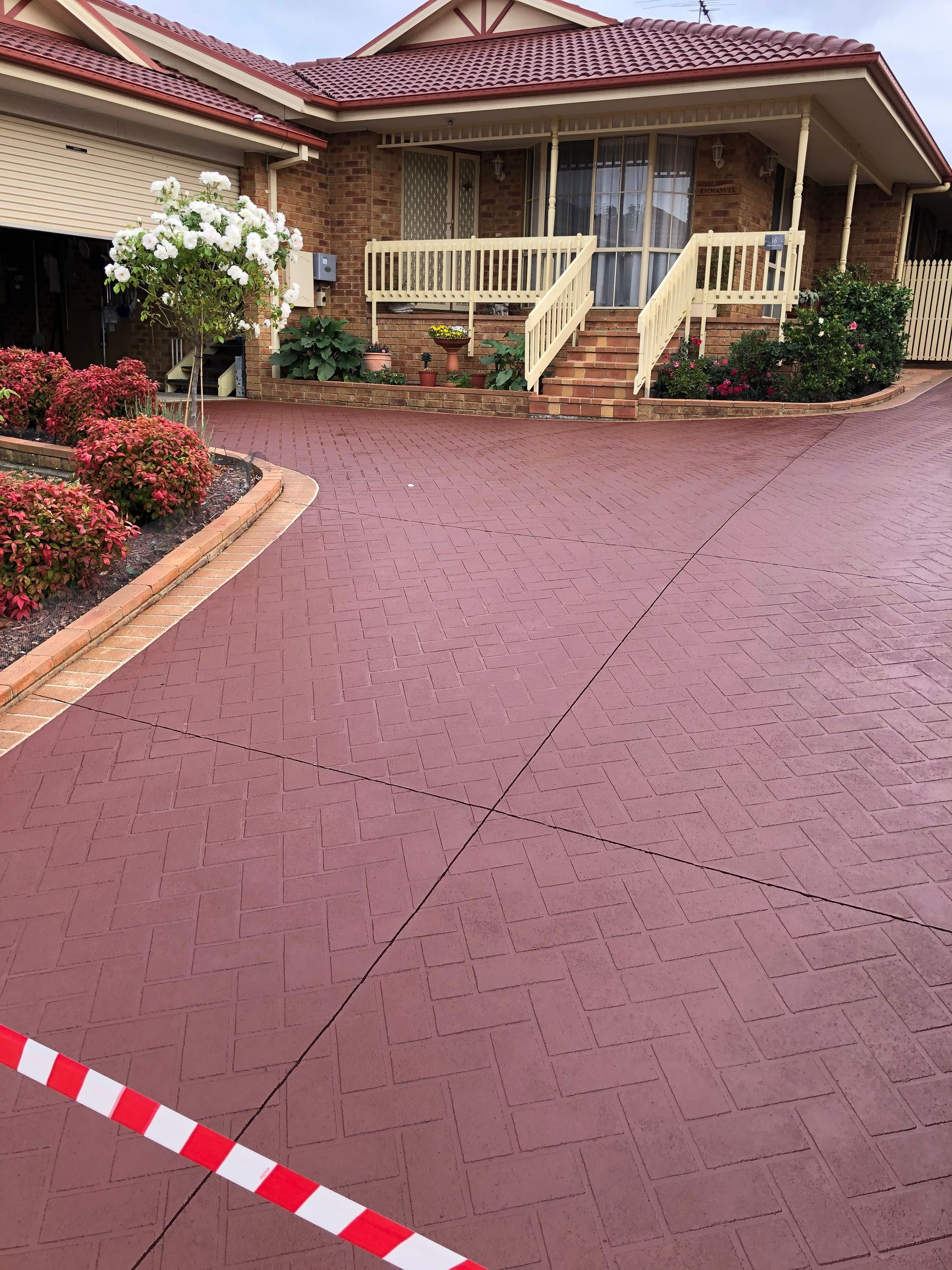 Red stencil driveway in Berwick sealed with Prime Exposure by Melbourne Concrete Sealing and Resurfacing.