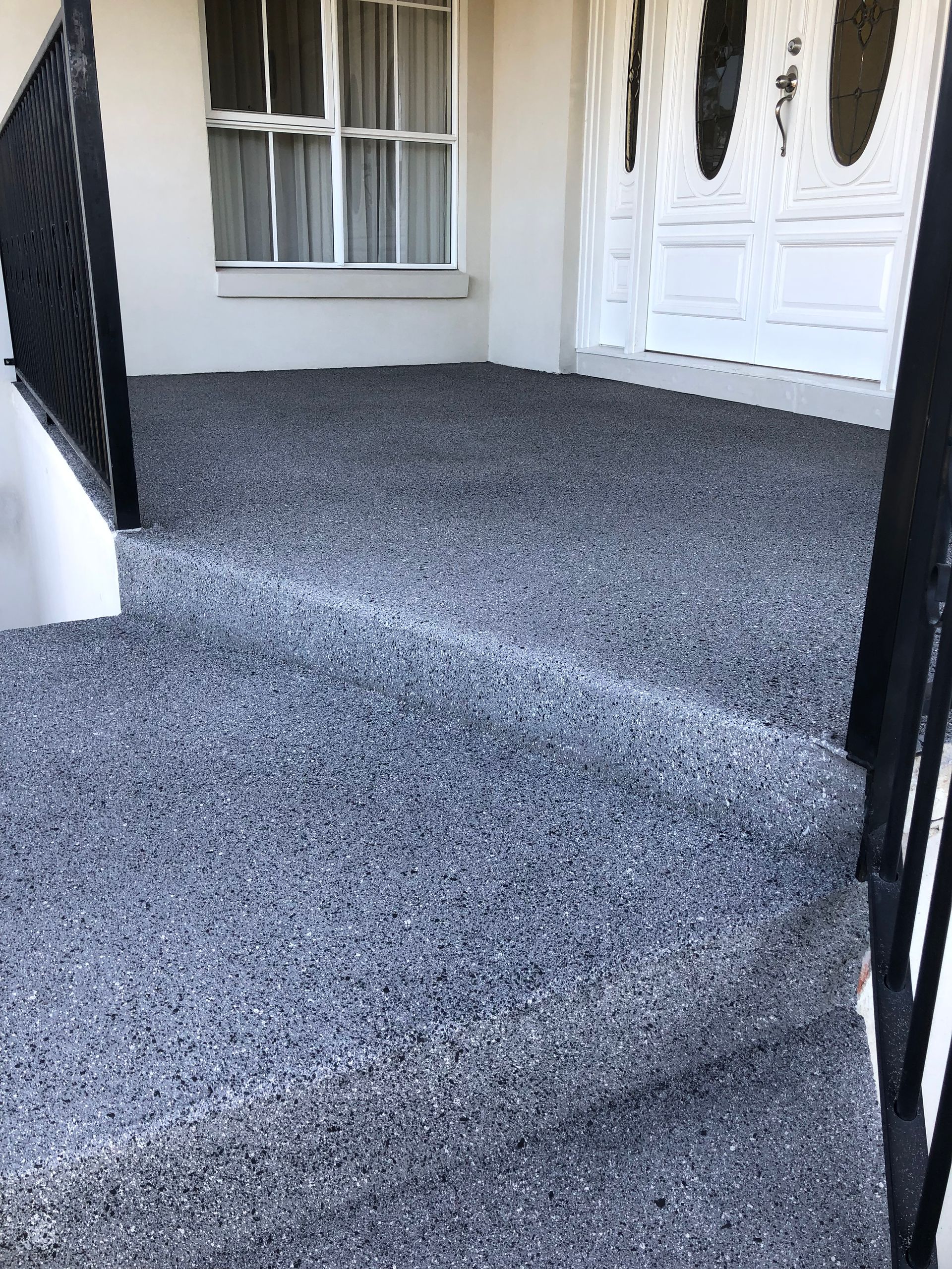 Custom colour concrete resurfacing on a front door landing and staircase entrance, professionally finished by Melbourne Concrete Sealing and Resurfacing in Templestowe.