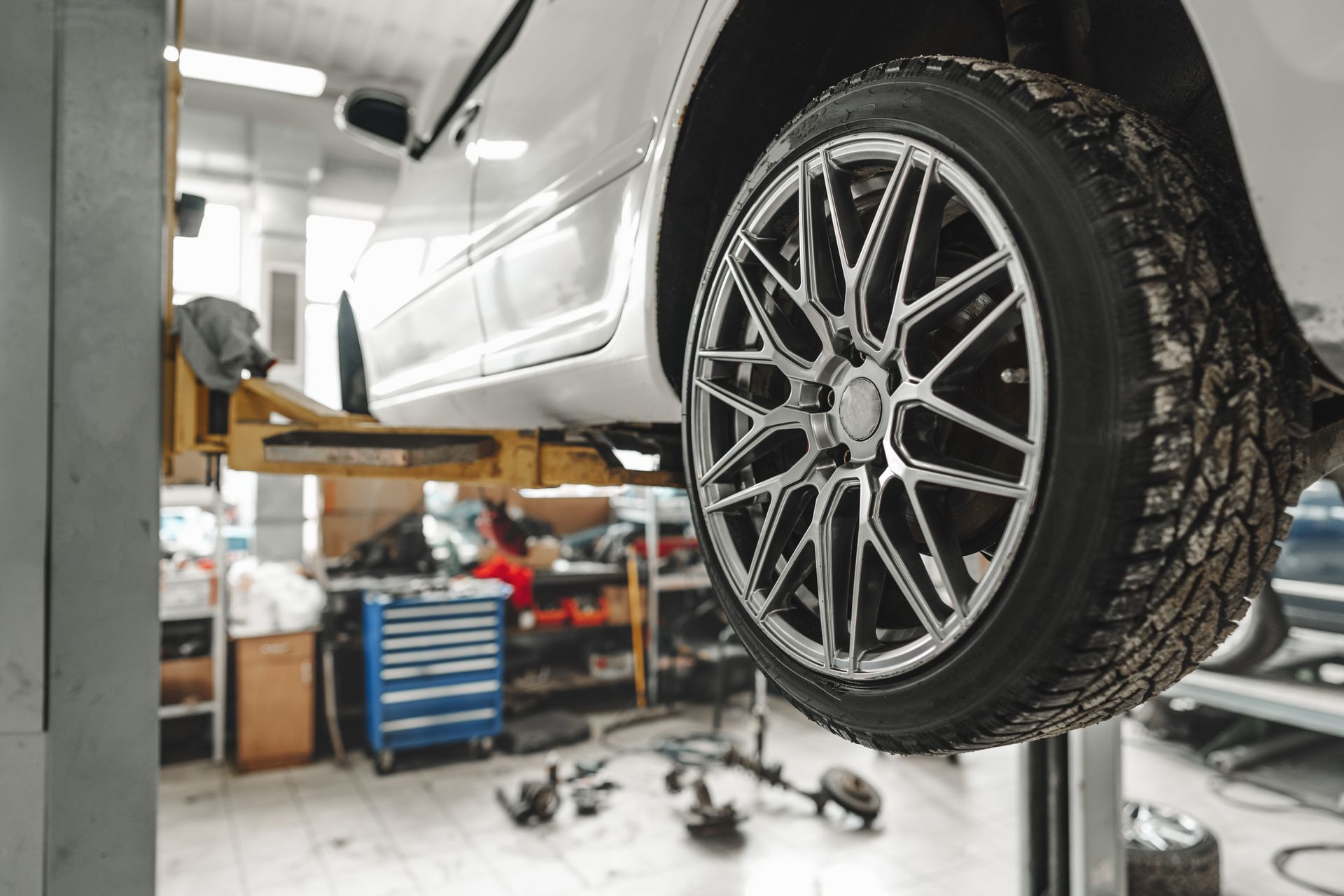 Silver Car Lifted on A Garage Hoist — Ballina Tyrepro in Alstonville, NSW