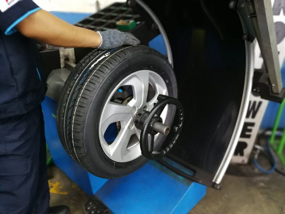 Man Wearing Gloves Holding The Tyre — Ballina Tyrepro in Ballina, NSW