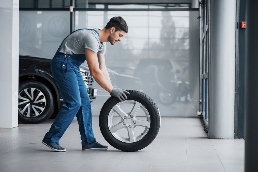 Man Holding A Tire At The Repair Garage — Ballina Tyrepro in Ballina, NSW