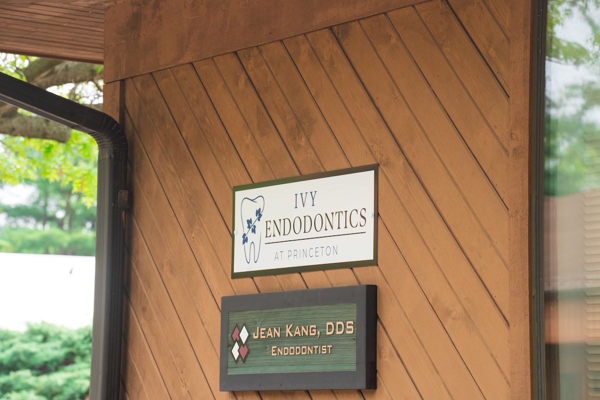 Sign on a wood wall for an orthodontics office, with a smaller pet boarding sign below.