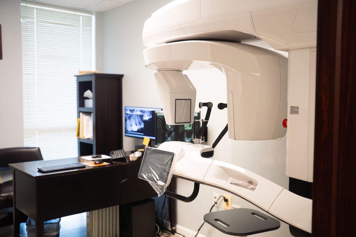 Modern medical imaging room with a large white scanner and desk equipment near a window