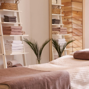 Cozy bedroom with a white bassinet, bedside cart, and pink curtains in warm light