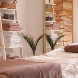 Cozy bedroom with a white bassinet, bedside cart, and pink curtains in warm light