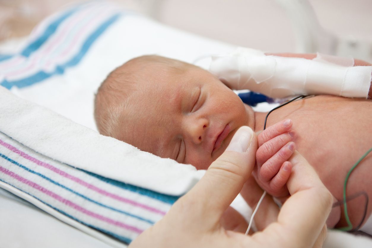 Uma pessoa está segurando a mão de um bebê recém-nascido