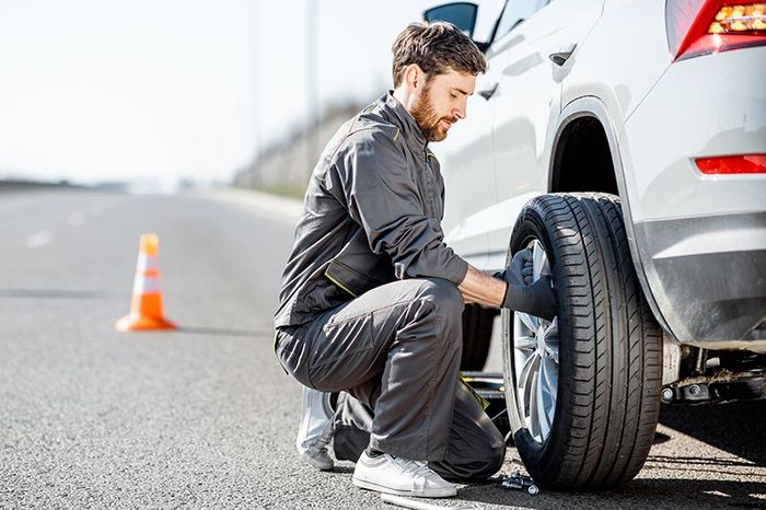 Worker Fixing The Car Wheels