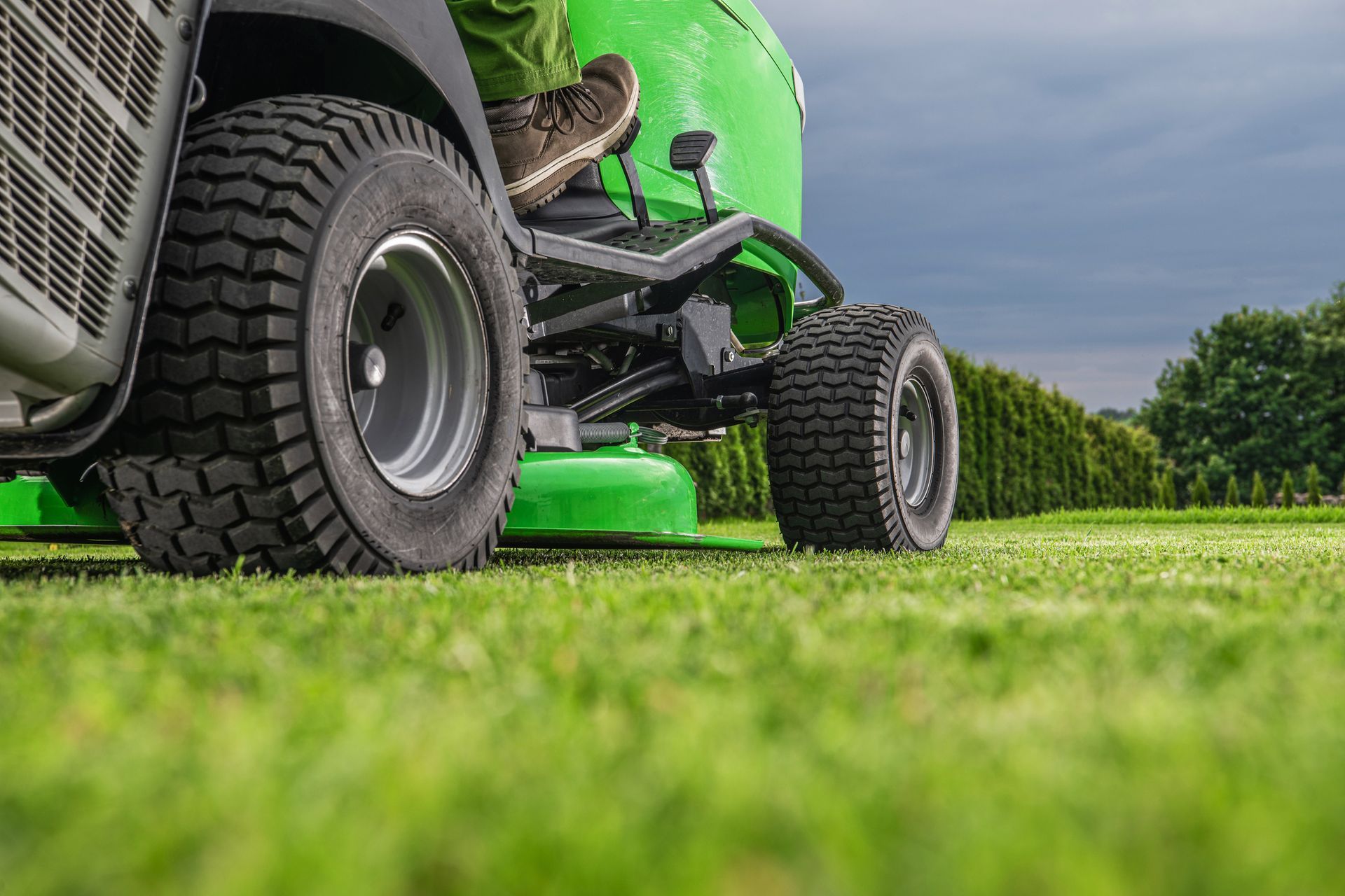 Lawn tractor dealer image of outdoor power riding lawn tractor on green yard. Lawn tractor dealer image of outdoor power riding lawn tractor on green yard.