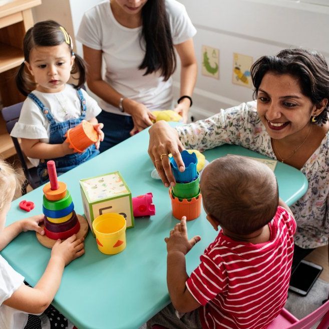 A group of children are playing with toys at a table