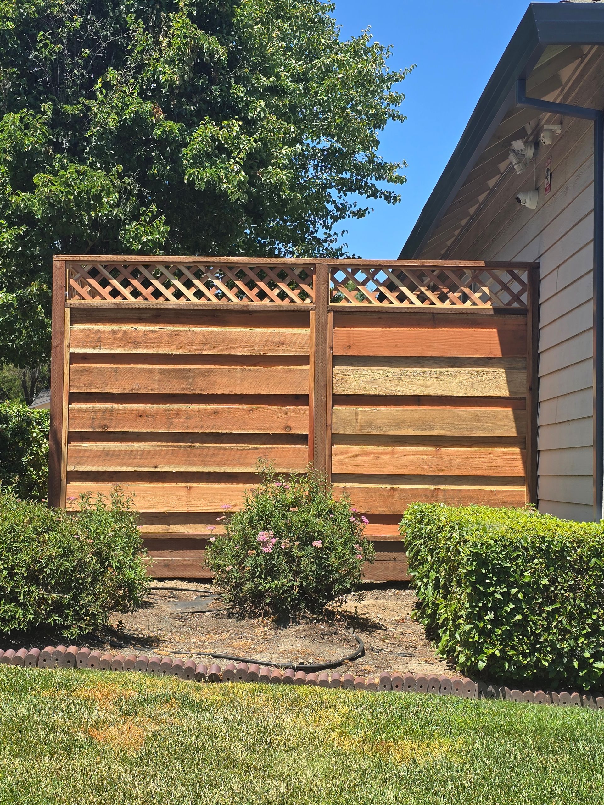 A wooden fence is sitting in front of a house.