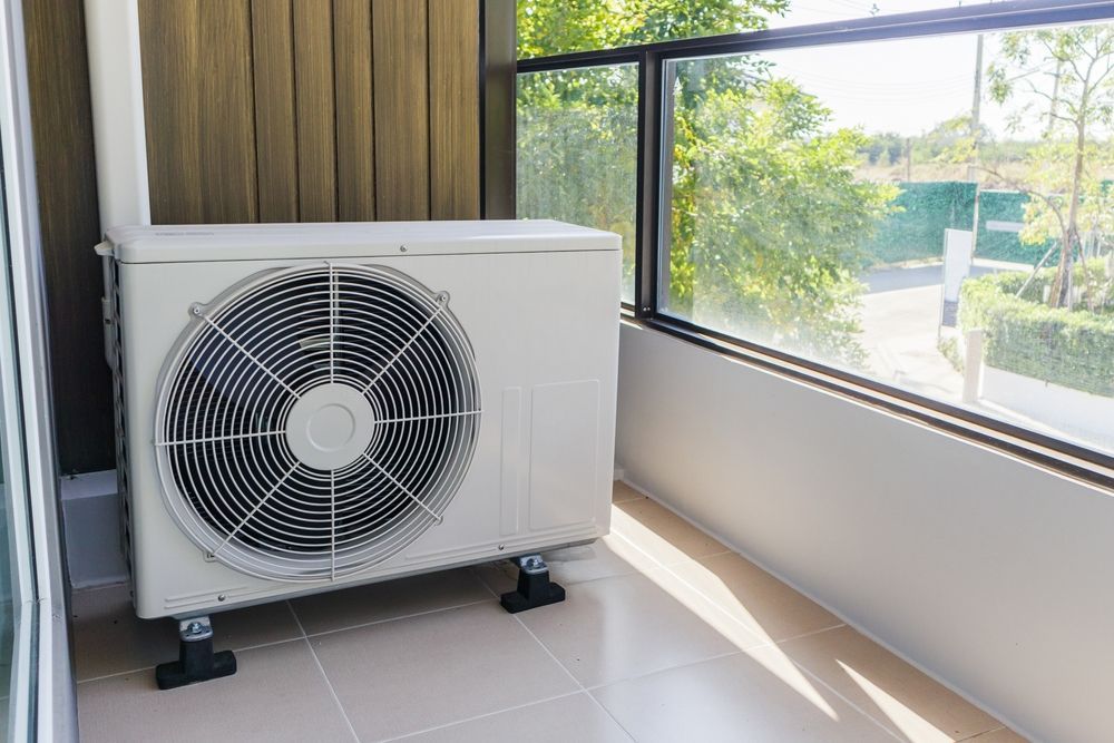 Two Air Conditioners Are Covered in Snow in Front of a House — BJ Heating & Cooling in Rutherglen, VIC
