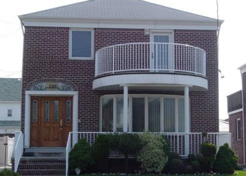 A brick house with a balcony on the second floor