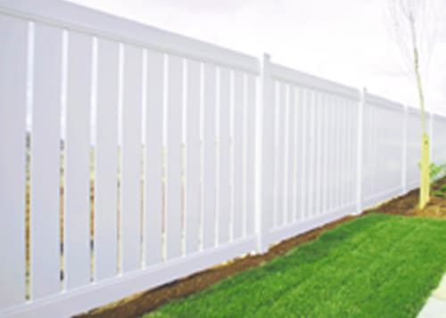 A white fence surrounds a lush green yard.