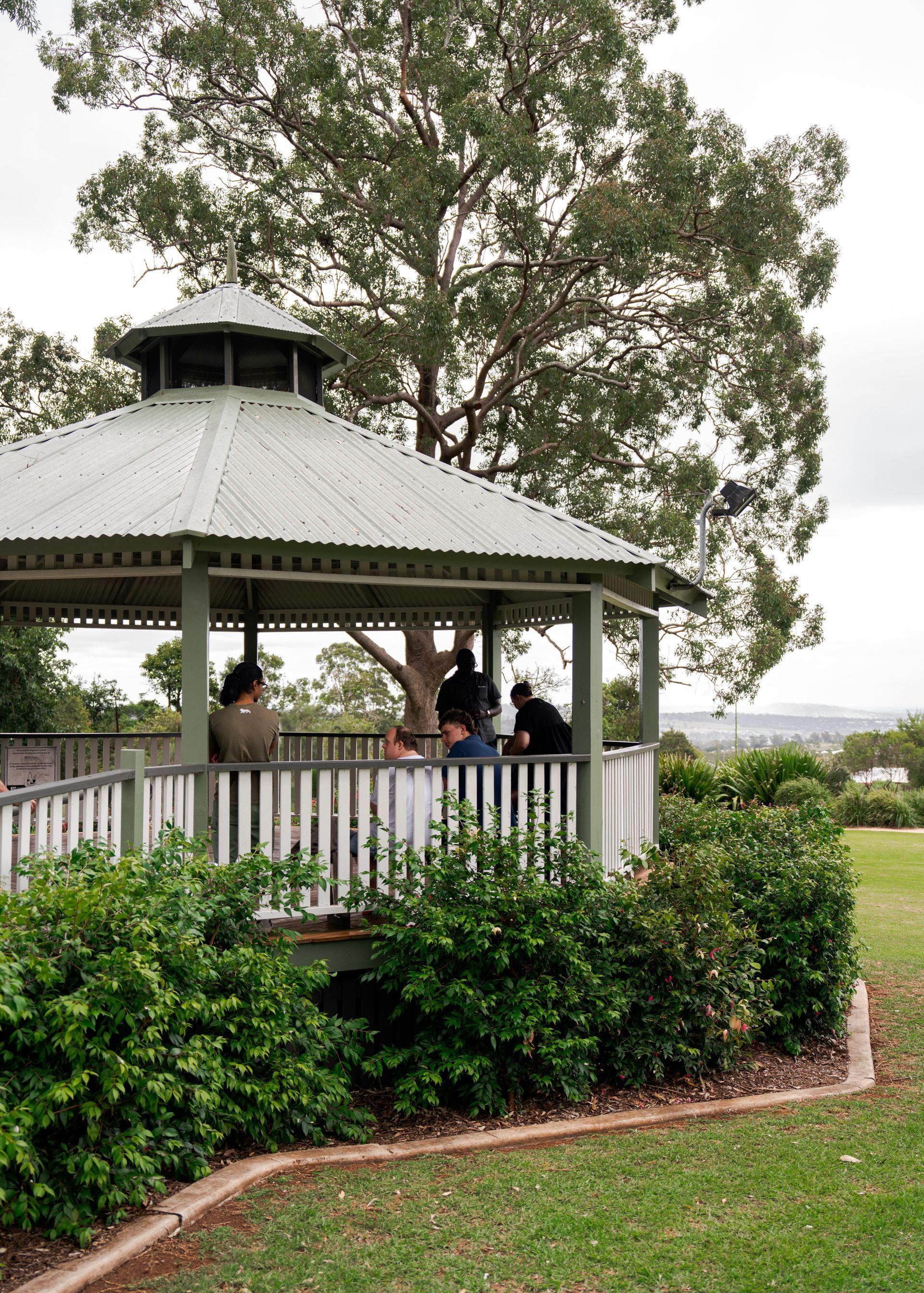 Clients and staff under a pergola at the park