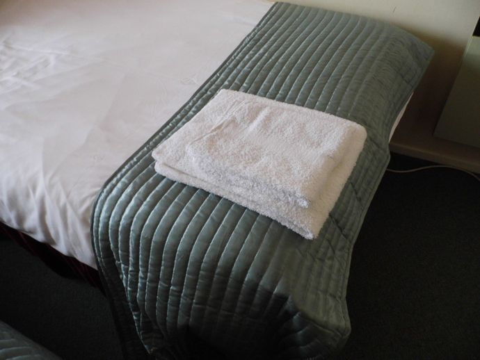 bed made up for guest arrival with all bed linen and towels in Wherry cottage.