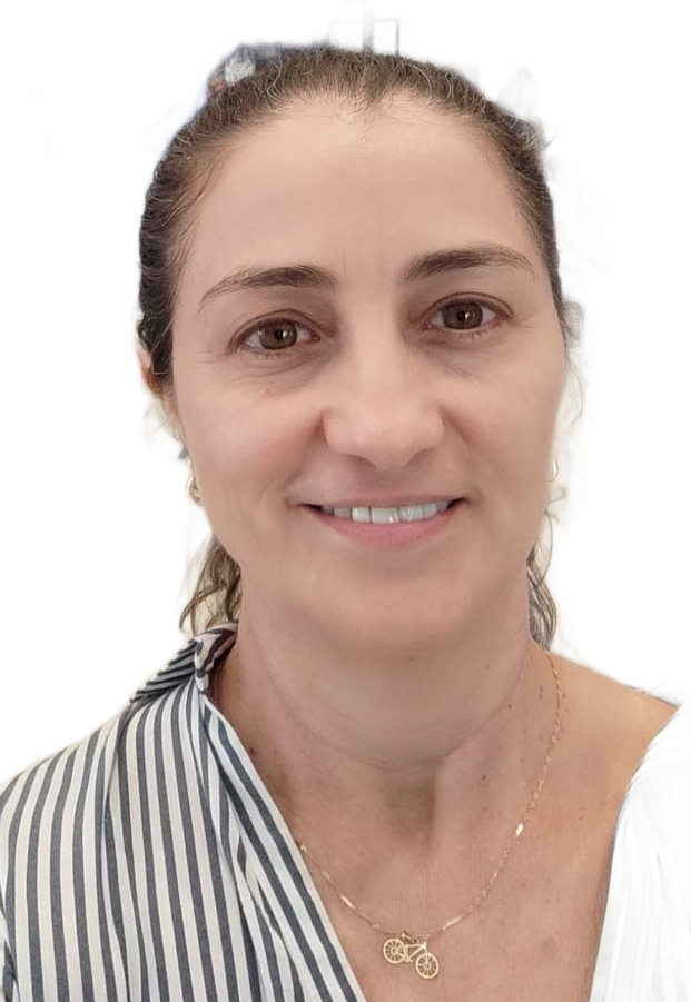 Uma mulher de camisa rosa está sorrindo em um campo.