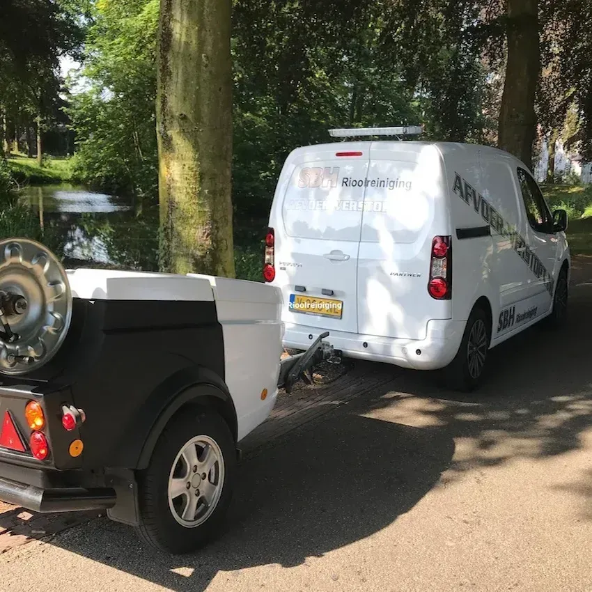 Bedrijfswagen met aanhanger en hogedrukinstallatie voor rioolreiniging