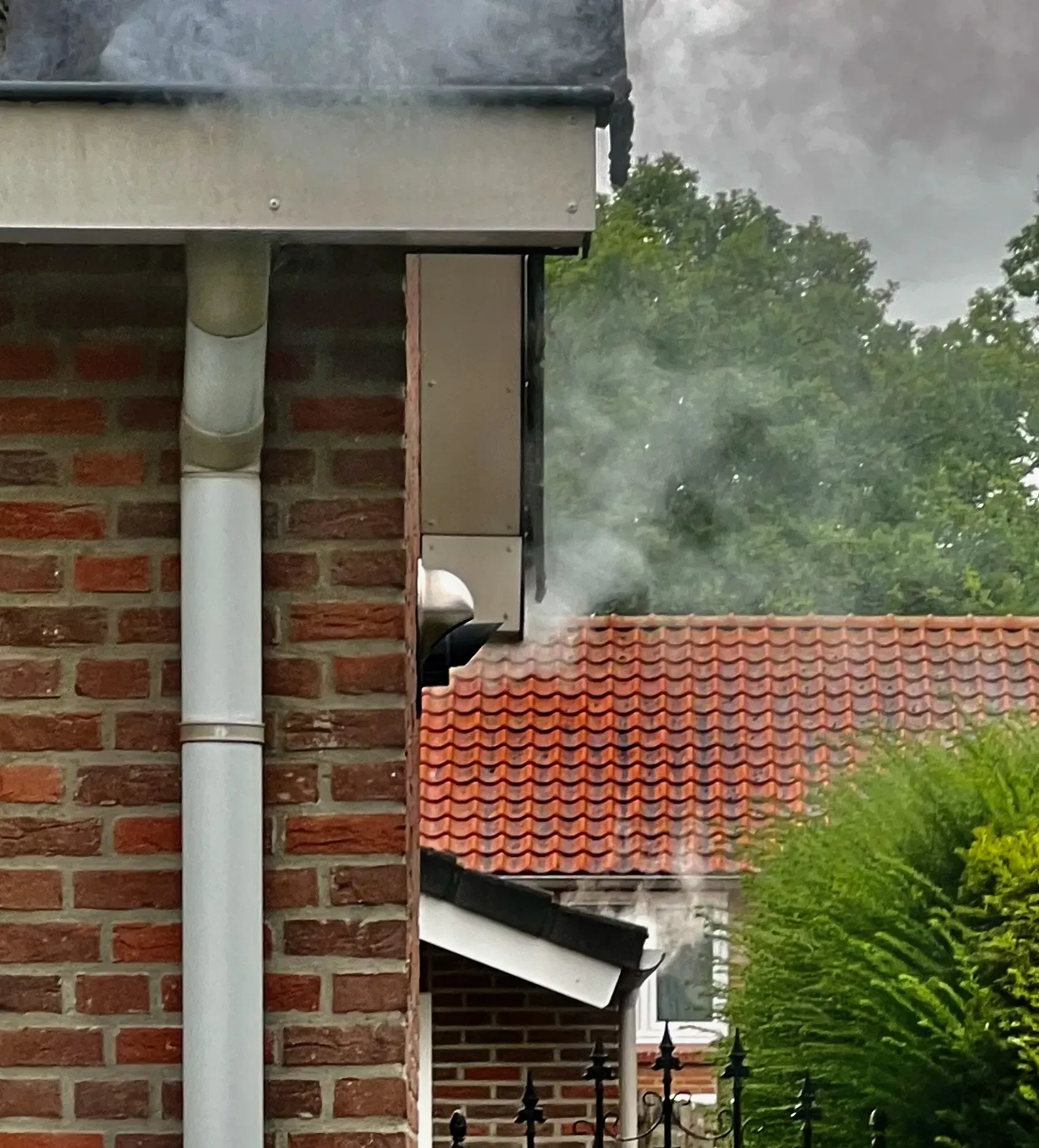 Rooktest bij regenwaterafvoer waarbij witte rook een open rioolverbinding zichtbaar maakt