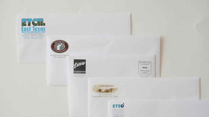 Four white envelopes with different company logos.