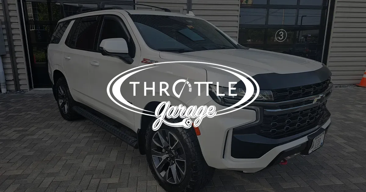 A white suv is parked in front of a building.
