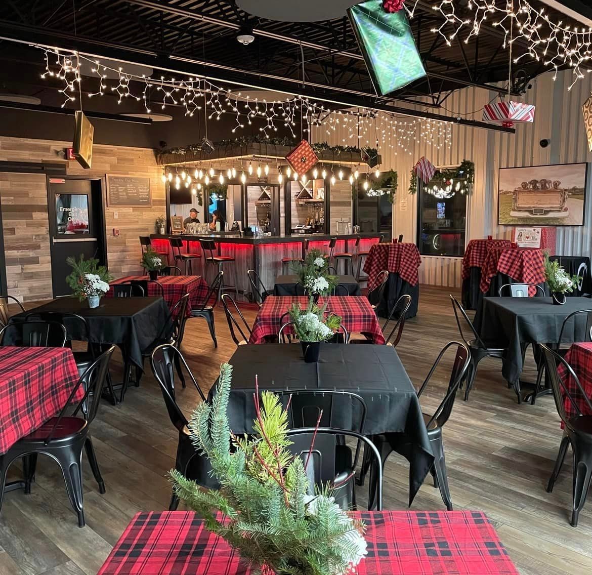 A restaurant filled with tables and chairs and christmas lights.