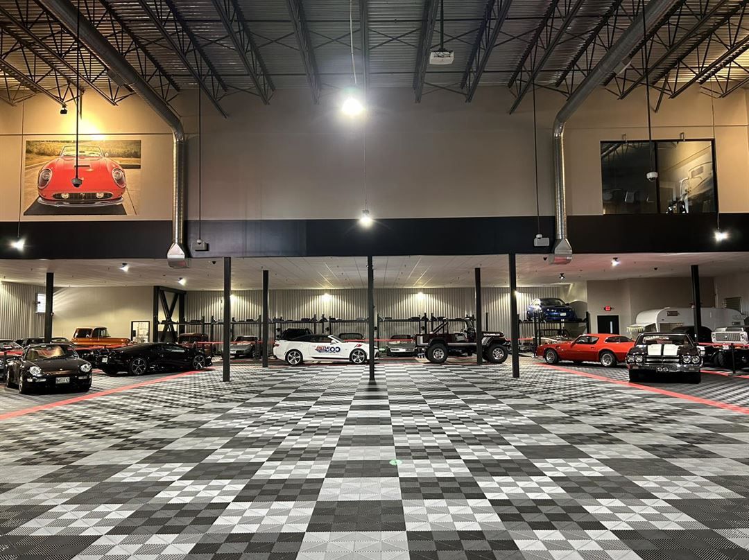 A large garage filled with cars and a checkered floor.