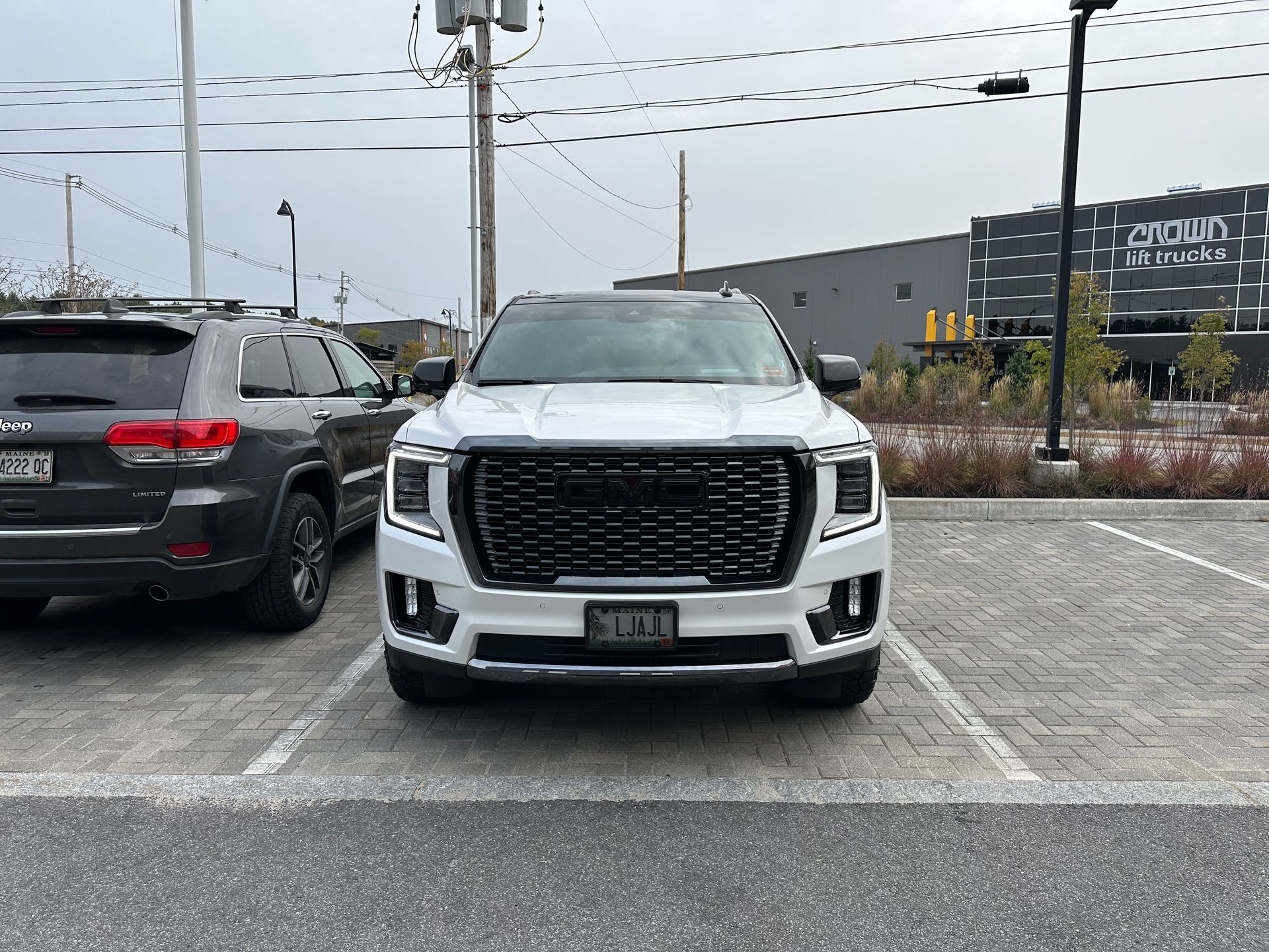 A white suv is parked in a parking lot next to a black suv.