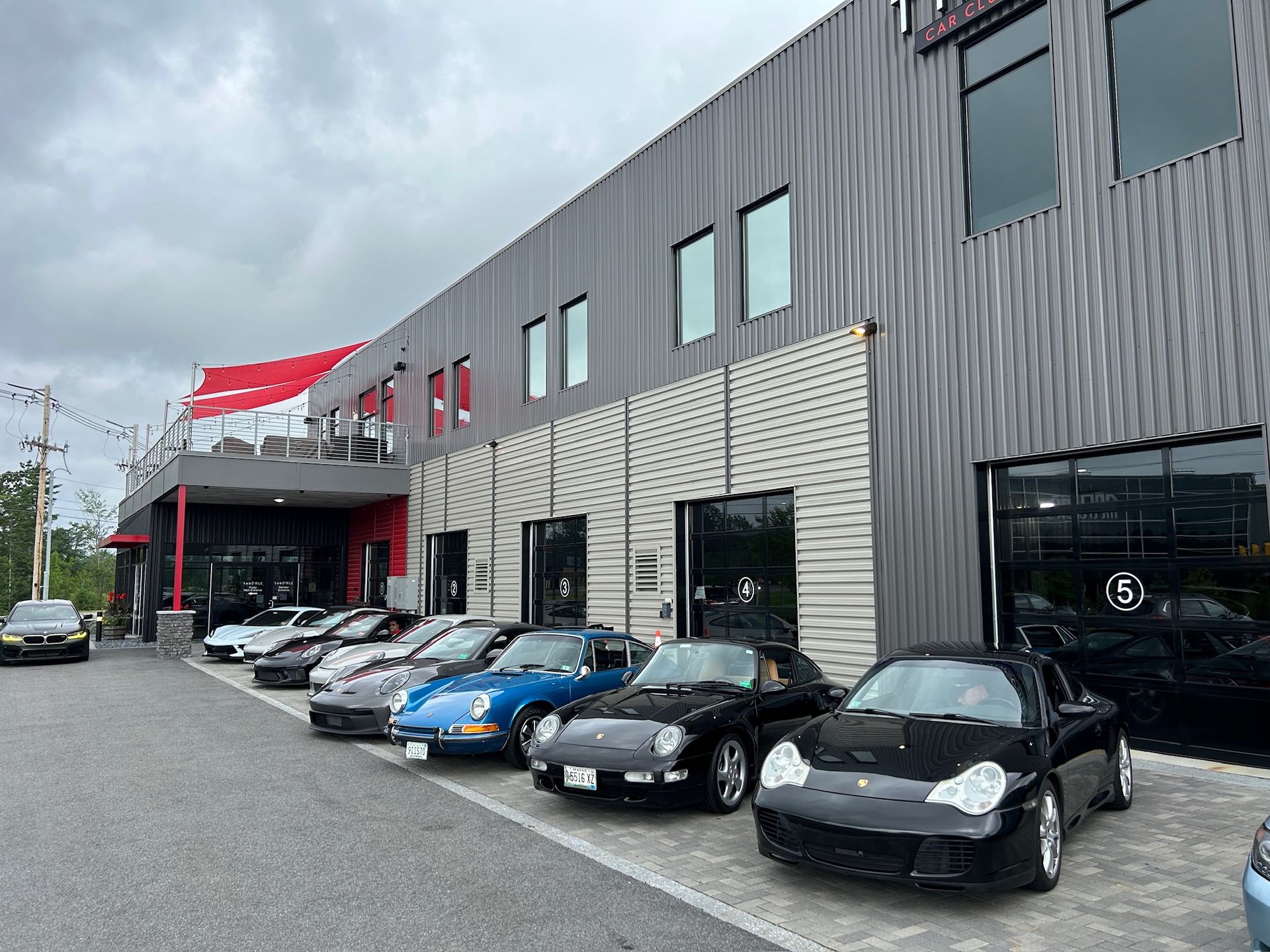 A row of cars are parked in front of a building.