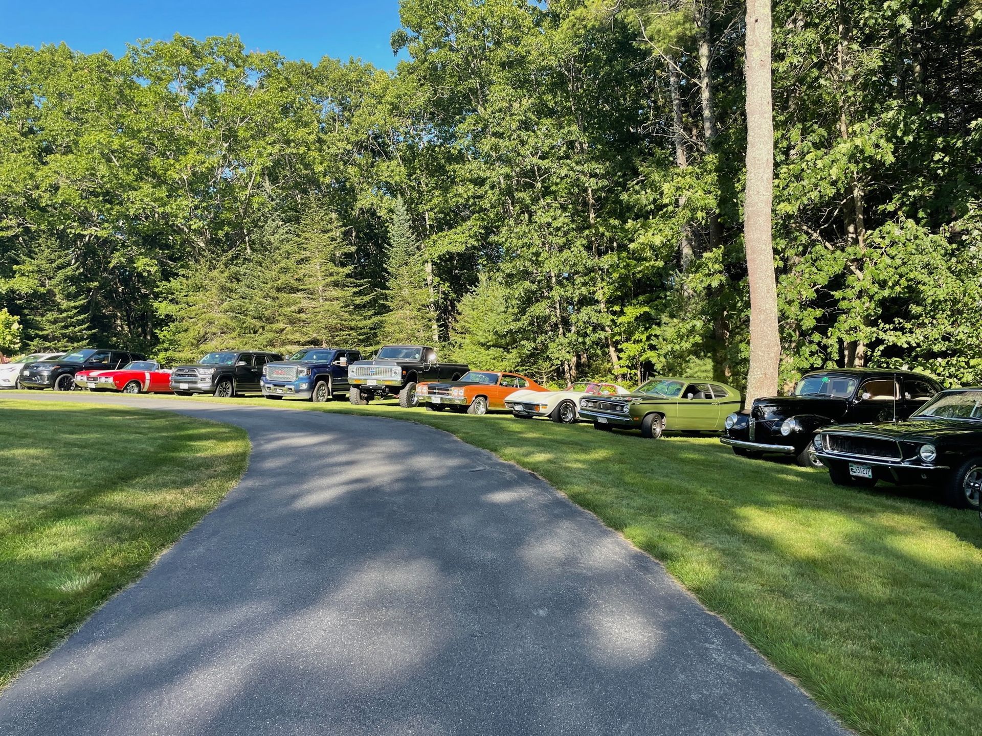 A row of cars are parked on the side of a road.