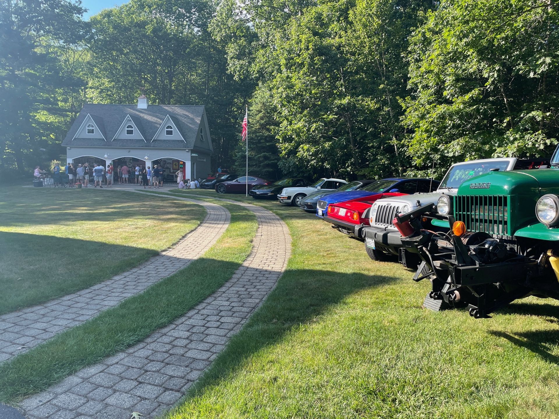 A row of cars are parked in front of a house.