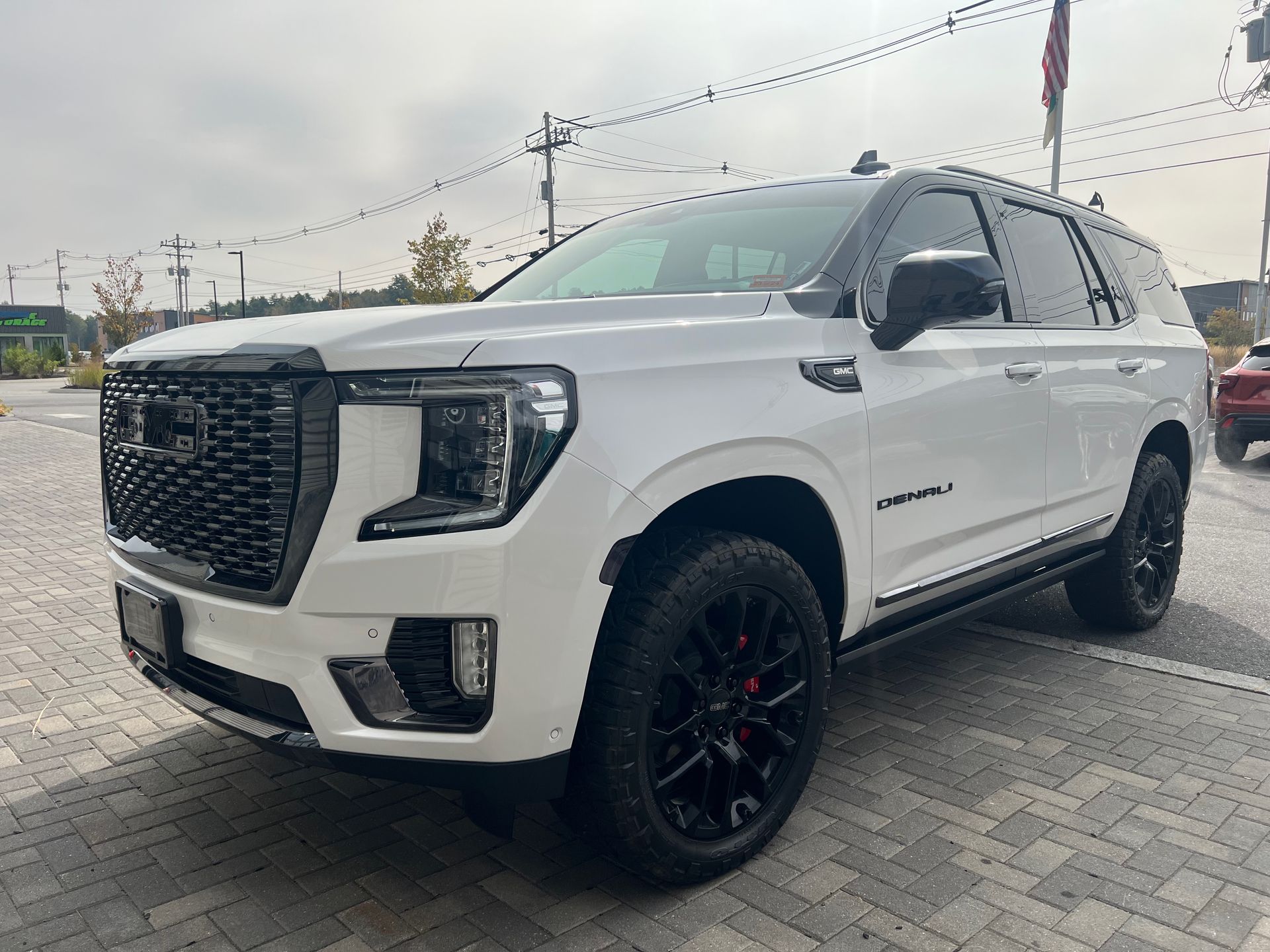 A white gmc yukon is parked in a parking lot.