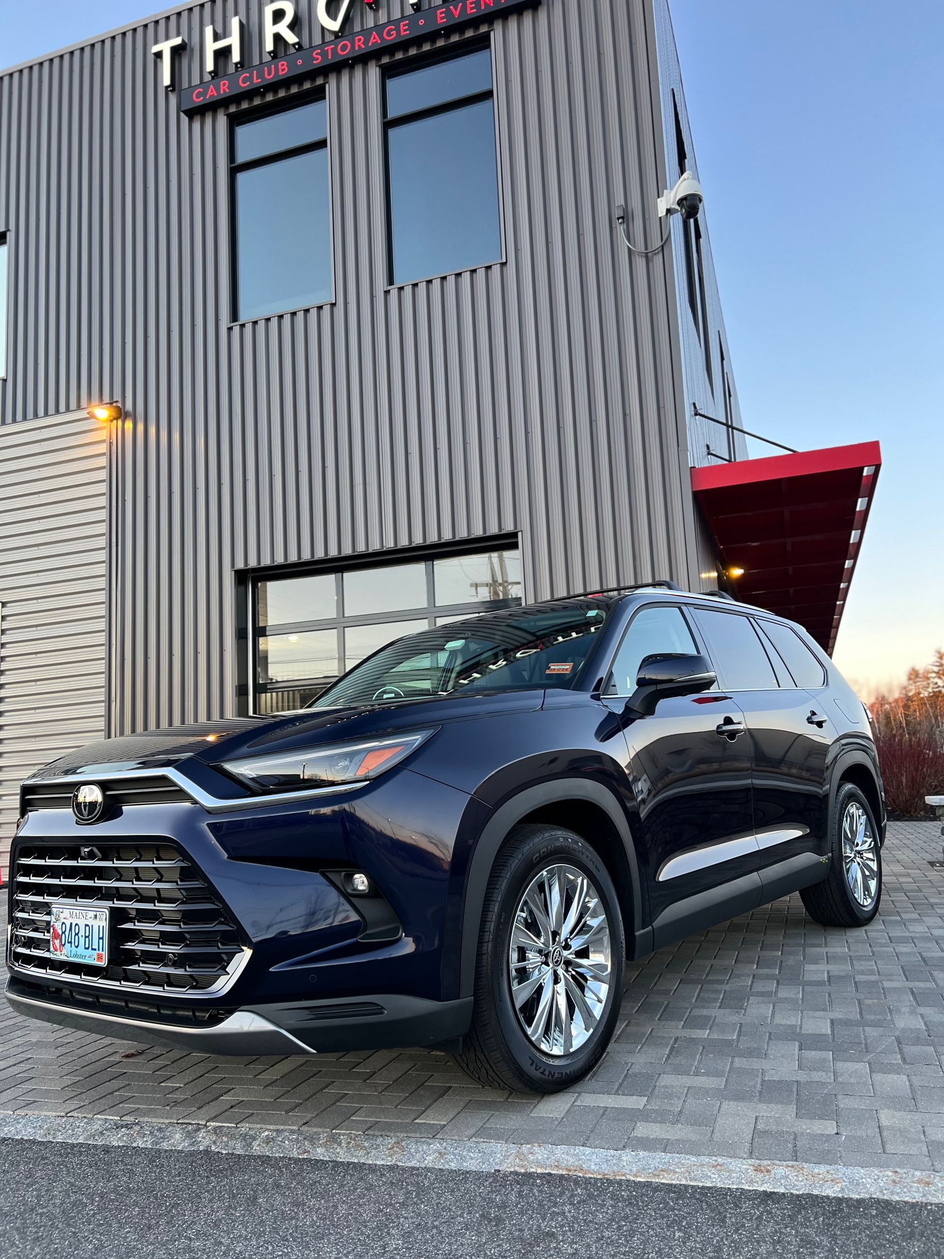 A blue car is parked in front of a building.