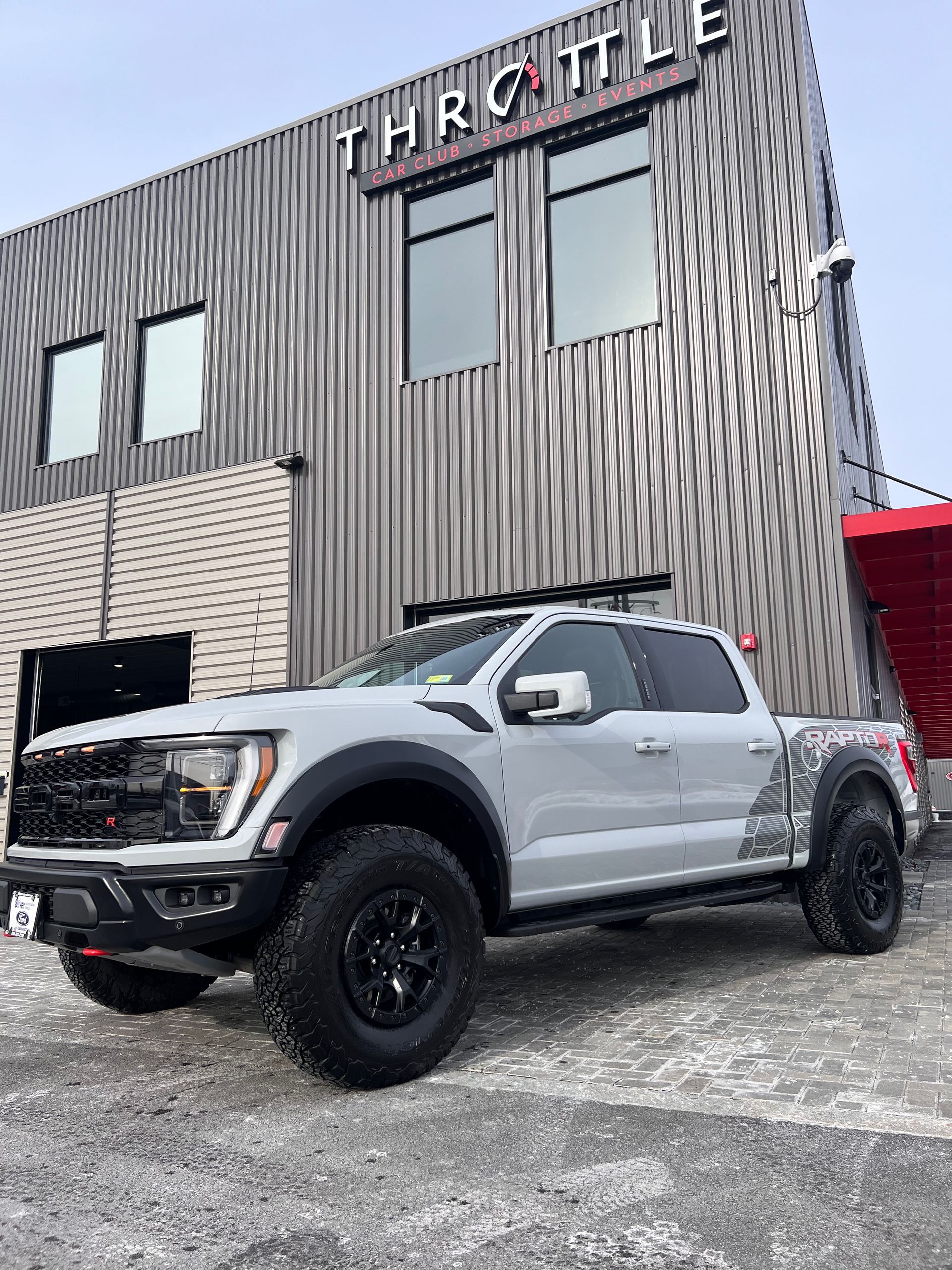 A white truck is parked in front of a building.