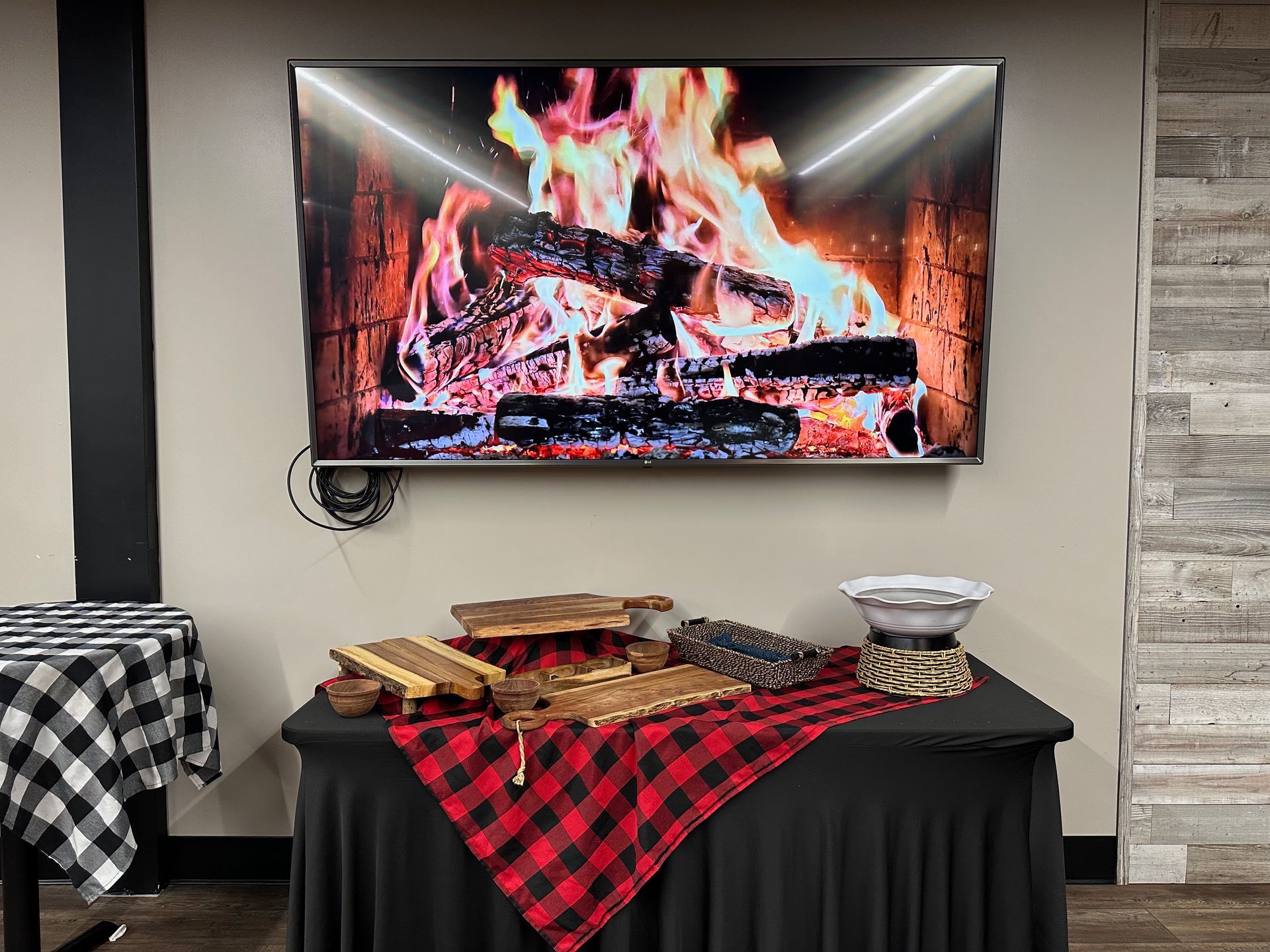 A flat screen tv is hanging on a wall above a table.